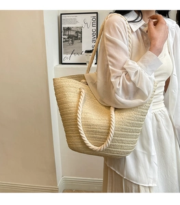 Detail showing the natural texture and rope handle of the beige woven tote bag