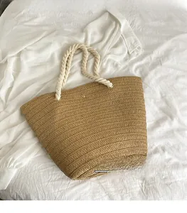 Detailed macro view of woven straw tote bag texture and durable thick cotton rope handles