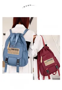 Detail view of large capacity nylon backpack with drawstring and buckle in blue and burgundy
