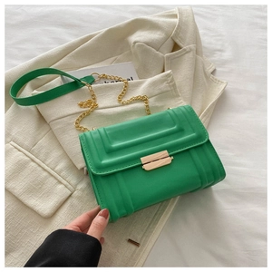 Detail of bright green leather crossbody bag with tiered embossing and gold hardware