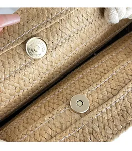 Detail of golden magnetic clasp closure on handmade woven straw tote bag texture