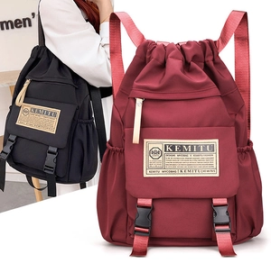 Detail view of burgundy and black drawstring backpacks with durable nylon and buckles