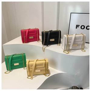 Five stylish small square chain bags in vibrant colors displayed on white steps