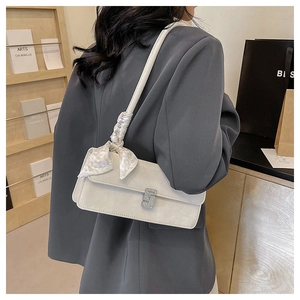 Détail du sac à bandoulière crème avec poignée en foulard de soie et boucle argentée