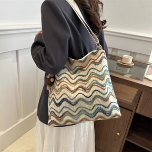Detail of colorful striped woven velvet tote bag with texture and a plush charm