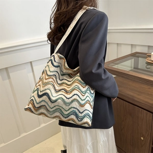 Detail of multi-color woven velvet tote bag with retro wavy pattern and wide strap