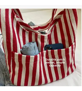 Detail van rood-wit gestreepte canvas tas met duurzame zakken en textuur