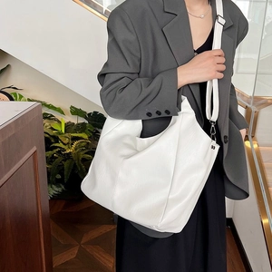 Detail view of large white PU hobo bag featuring adjustable strap and soft pleated texture