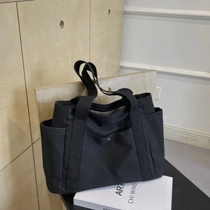 Large capacity black canvas tote bag with side pockets for daily commute and leisure