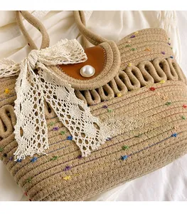 Close-up of woven tote bag with lace bow, rainbow fiber accents, and pearl button detail
