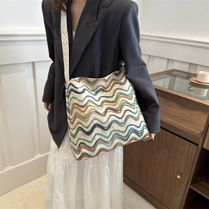 Close-up of colorful wavy woven texture and geometric strap on a velvet tote bag
