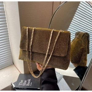Detailed view of shimmering gold sequin texture and chain strap on a designer tote bag