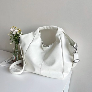 Detail of white large capacity tote bag with textured PU leather on a minimalist desk