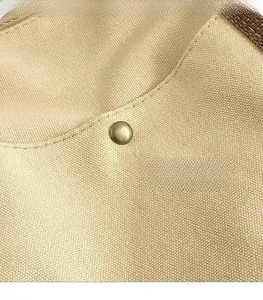 Close-up of beige canvas fabric texture with bronze snap button and brown shoulder strap