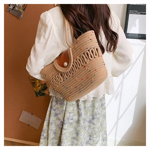 Detail of hollow woven cotton bag with premium leather flap and elegant pearl closure