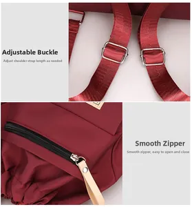 Detail of adjustable straps with silver buckles and leather zipper pulls on burgundy backpack