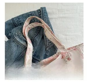 Dettaglio delle cuciture raffinate sul manico di una borsa tote rosa floreale