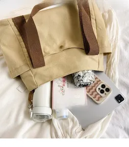 Large khaki canvas tote bag interior showing capacity for umbrella, book, and tablet