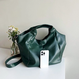 Detail of dark green oversized tote bag with lychee texture and dual strap design