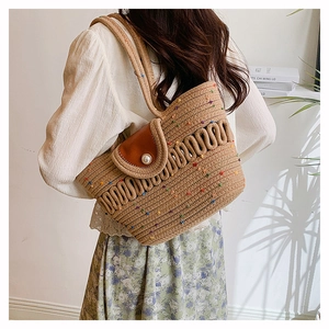 Detail of hollow woven shoulder bag with colorful dots, leather flap, and large pearl buckle