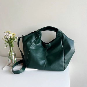 Detail of dark green tote bag with lychee texture leather and adjustable shoulder strap