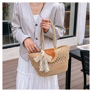 Detail of hollow woven cotton bag with lace bow and leather handle for summer