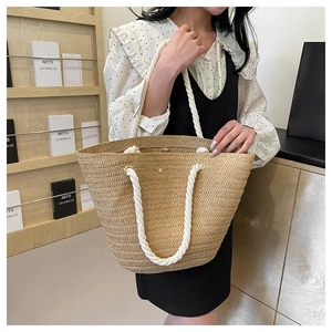Detail of woven tote bag showing white cotton rope handles and gold magnetic closure