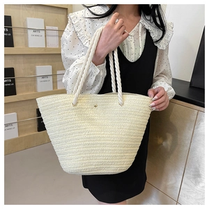 Close-up of beige woven tote bag with rope handles and textured straw pattern detail