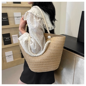 Detail of summer woven tote bag featuring white cotton rope handles and straw texture