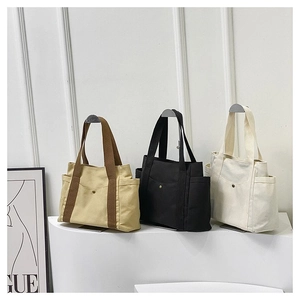 Detailed view of canvas tote bags with front snap pockets and practical side pouches