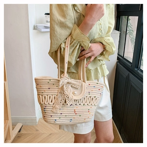 Detail of hand-woven cotton tote bag featuring colorful dots and lace bow decoration