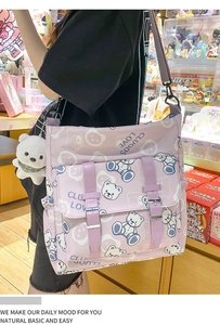 Detail of purple bear print crossbody bag with plush charm and buckle straps
