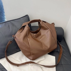 Detail view of large brown tote bag with soft PU leather texture and shoulder strap