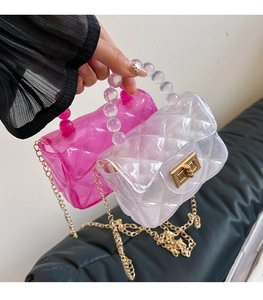 Détail de mini sacs gelée à motif matelassé, poignées en perles et chaînes dorées