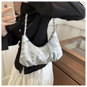 Detailed view of silver pleated crescent bag with metallic finish and braided shoulder strap