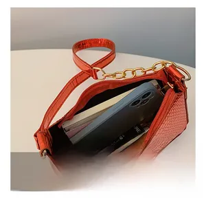 Macro view of red crocodile-embossed bag interior showing spacious storage capacity