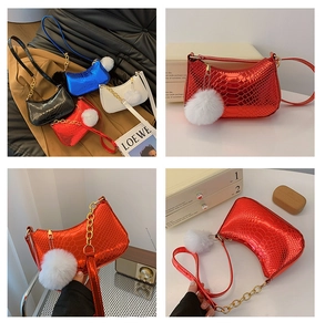 Detail of metallic lizard-pattern crossbody bags with plush ball charms and gold chain straps