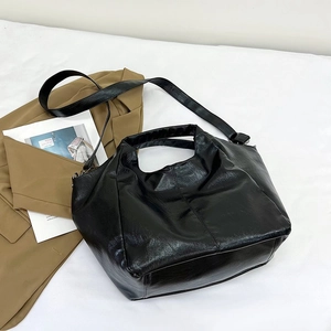 Detail of black PU leather tote bag with soft texture and adjustable shoulder strap
