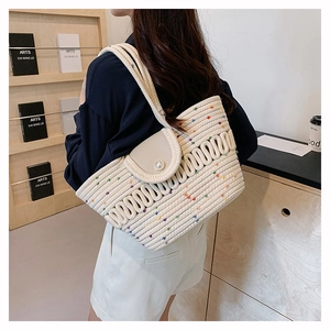 Close-up of woven tote bag with colorful wave embroidery and decorative pearl button