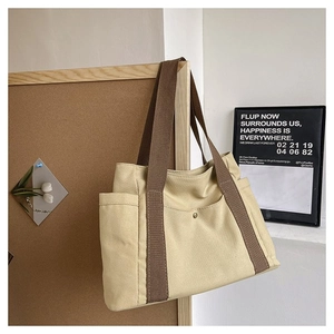 Macro detail of canvas tote bag with brown straps and functional metal snap button pocket