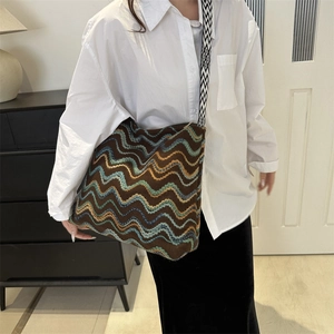 Detailed close-up of a large woven tote bag with wavy patterns and geometric strap