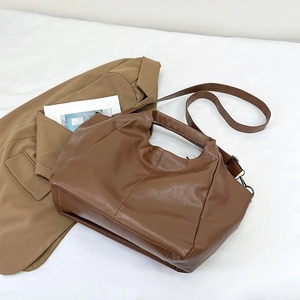 Detail of deep brown lychee grain PU leather handbag with detachable shoulder strap