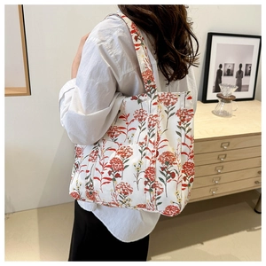 Borsa tote in tela a fiori indossata da una modella in un interno domestico accogliente