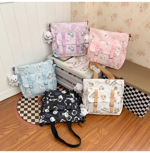 Detail of five colorful canvas messenger bags with cute bear prints and matching plush charms