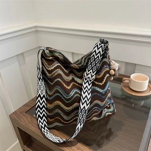 Detail of bohemian woven tote bag with wavy patterns and geometric shoulder strap