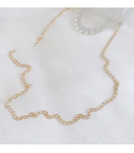 Détail d'une fine bandoulière dorée en métal pour petit sac à main en gelée transparente