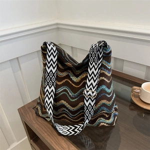 Detail of colorful wavy striped velvet tote with adjustable geometric shoulder strap