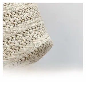Vue macro détaillée de la texture tissée beige de ce grand sac à main cabas en paille