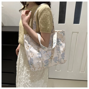 Dettaglio della borsa tote in tela con stampe floreali arancioni e blu per il pendolarismo