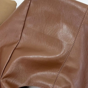 Close-up of brown leather texture and precision double stitching on the commuter tote bag